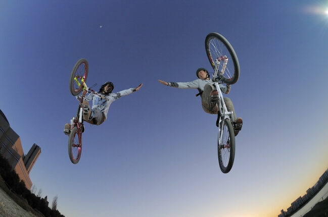 Sharing Talents Culture: Image is too cyclist in the air reaching toward each other