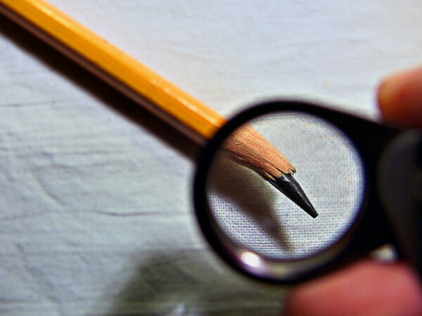 Human Trust Breakers: Image is Magnifying glass looking at broken pencil point.