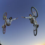 Sharing Talents Culture: Image is too cyclist in the air reaching toward each other