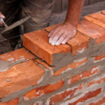Trivial Leadership Actions: Image is person laying bricks.